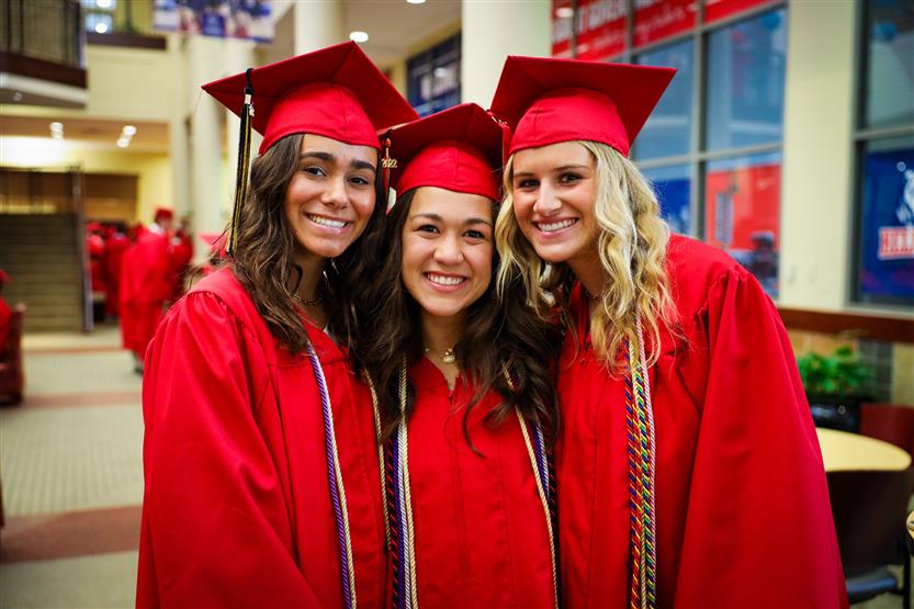 Students in red robes graduate